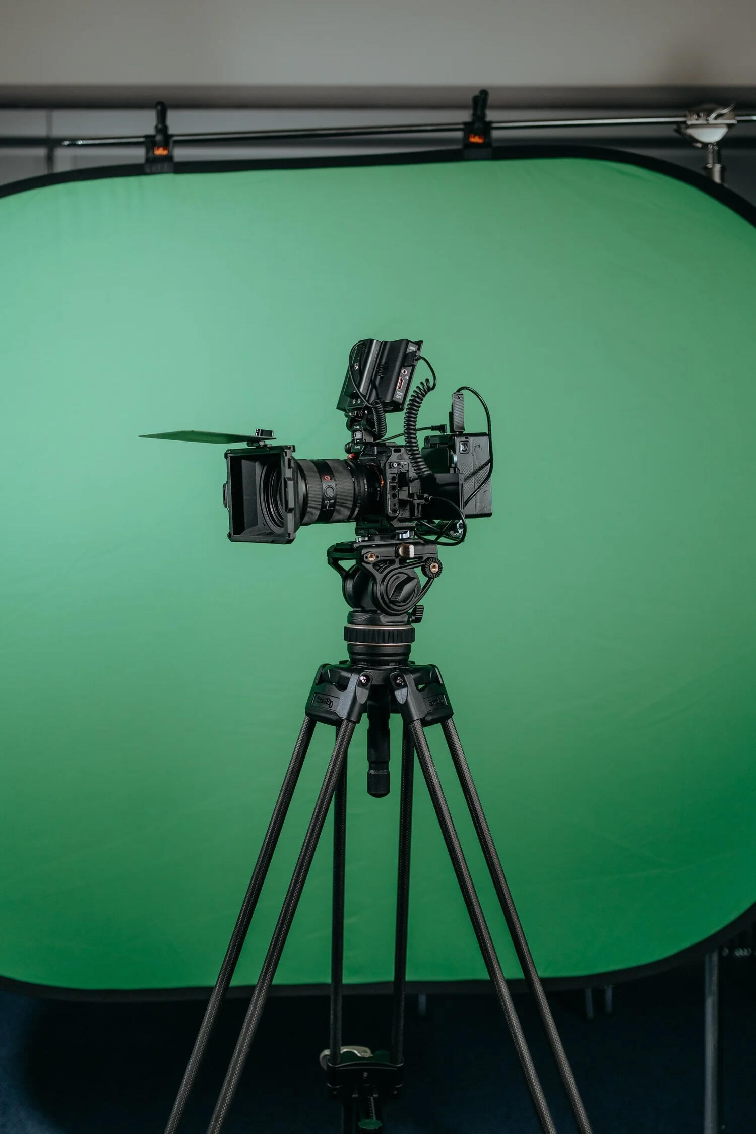 Video camera on tripod in green screen studio for BSL video production British Sign Language video production studio setup with professional camera and green screen
