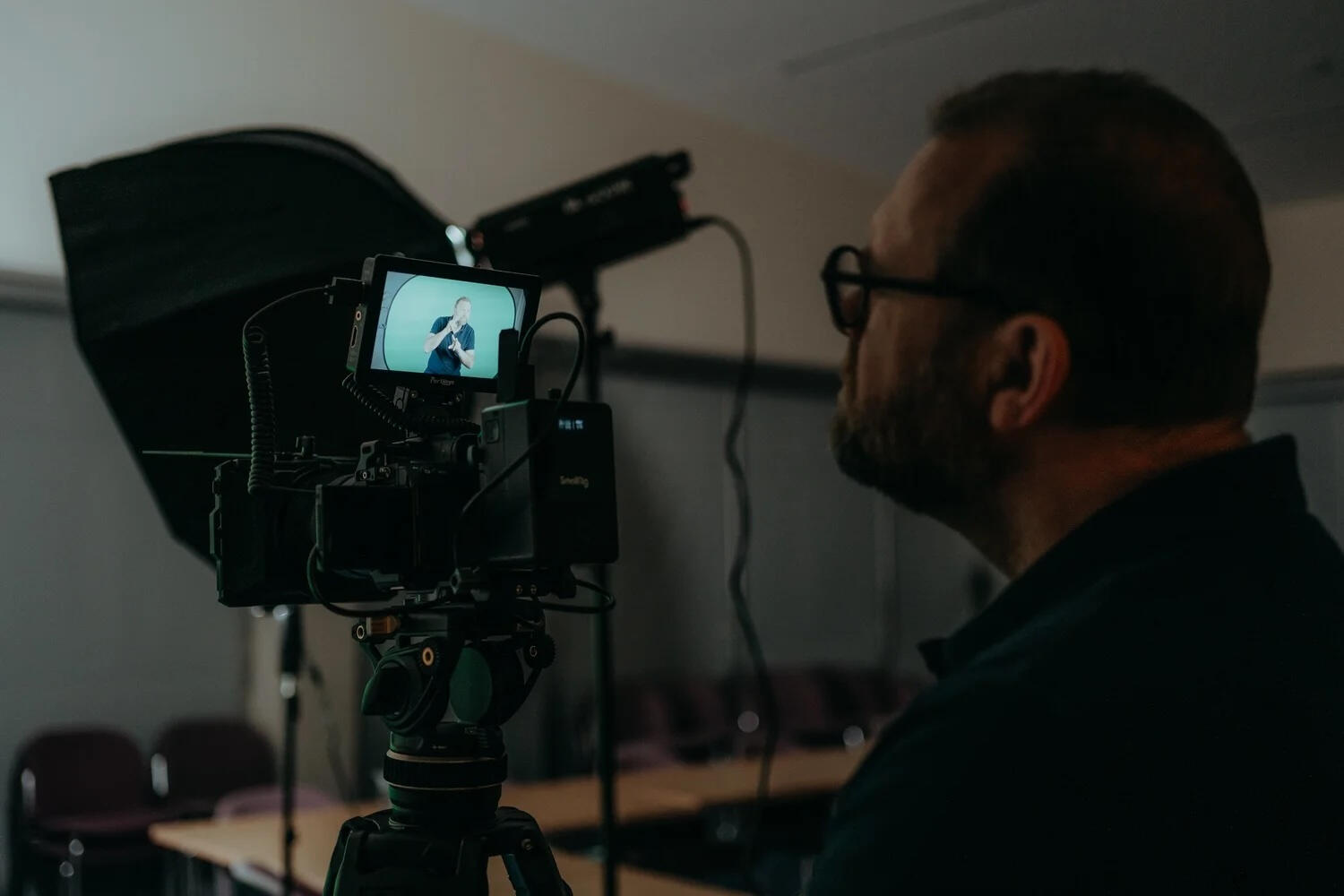 Camera monitor showing a British Sign Language presenter recording accessible video content